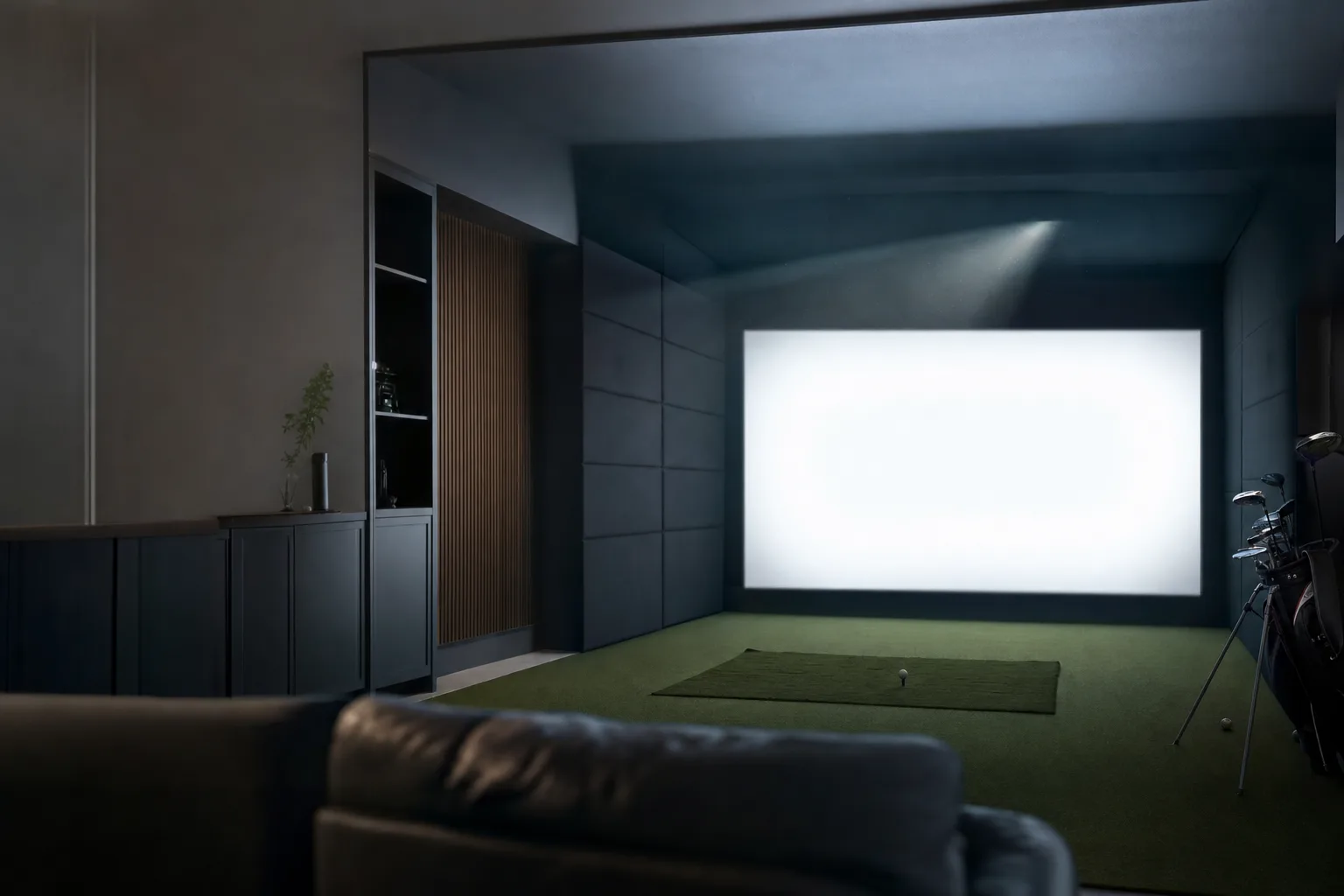 A dark home golf room with a bright blank impact screen lit by a ceiling-mounted projector beam visible in the haze